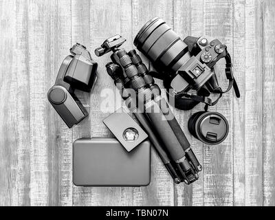 Retro Schwarz/Weiß-Fotografie, Kamera, Stativ, Blitz und Linsen an einer hölzernen Hintergrund Stockfoto