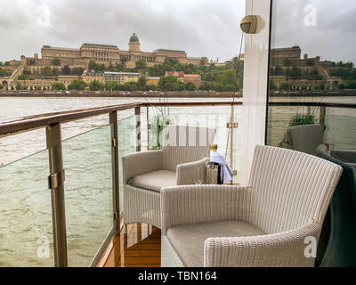 Leere Liegestühle mit einer Flasche Champagner auf dem Balkon von Luxus flussschiff Kreuzfahrtschiff an den Ufern der Donau in Budapest, Ungarn. Stockfoto