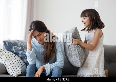 Betonte Mutter leiden unter Kopfschmerzen durch lautes Kind genervt Stockfoto