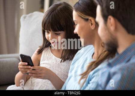 Smart Vorschüler Mädchen sitzen auf der Couch mit Smartphone Stockfoto