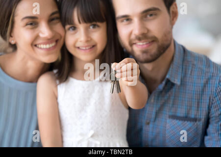 Aufgeregt, junge Familie mit Kind halten Sie die Tasten werden Eigenheimbesitzer Stockfoto