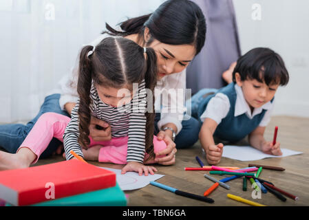 Mutter, die Kindern in der Klasse. Tochter und Sohn Gemälde mit bunten Kreide Farbe im Hause. Lehrer Ausbildung der Studenten in der Kunst Unterricht zu Stockfoto