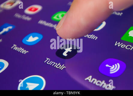 Finger, mit dem ein Symbol auf einem Smartphone oder Tablet-PC Touchscreen die Tumblr microblogging und soziale Medien App zu laden. Stockfoto