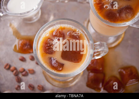 Iced Latte Kaffee kalt mit Eiswürfeln und Kaffeebohnen auf ein Fach Ansicht von Oben. Stockfoto