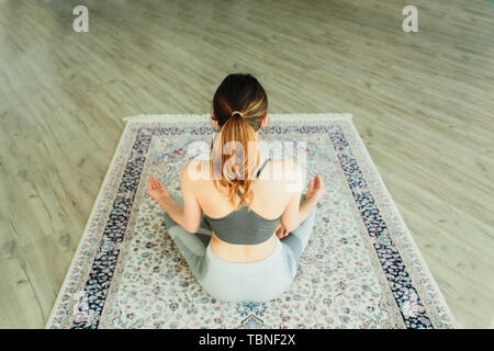 Junge attraktive lächelnde Frau Yoga in ein großes, helles Zimmer Stockfoto