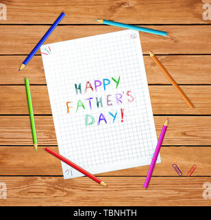 Happy Vatertag Typografie isoliert auf karierten Notebook Blatt oder graphischen Papier auf Holztisch mit Buntstiften. Kinder Hand Schrift geschrieben Stockfoto