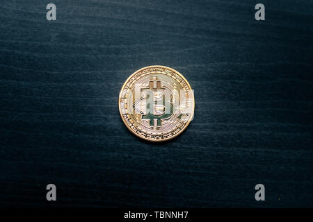 Eine physische Bitcoin in der Mitte eines dunklen Hintergrund Stockfoto