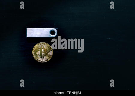 Physische bitcoin unter einem Hauptbuch Nano S Sichere kalten Geldbörse sitzen Stockfoto