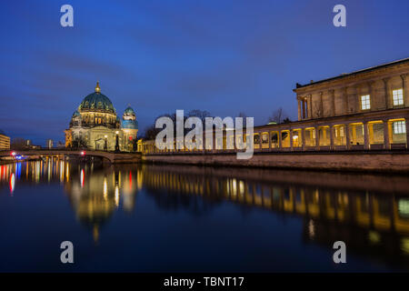 Beleuchtete Berliner Dom (Berliner Dom), Kolonnaden und ein Museum auf der Museumsinsel und Reflexionen auf der Spree in Berlin, in der Dämmerung. Stockfoto