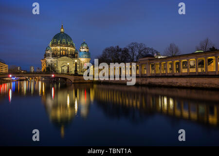 Schöne Aussicht auf die beleuchteten Berliner Dom (Berliner Dom) und Kolonnaden an der Museumsinsel und Reflexionen auf der Spree in Berlin in der Abenddämmerung. Stockfoto