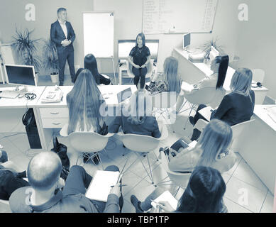 Ansicht der Rückseite. Zuversichtlich Geschäftsmann erklären, was auf dem Whiteboard während der Konferenz Stockfoto