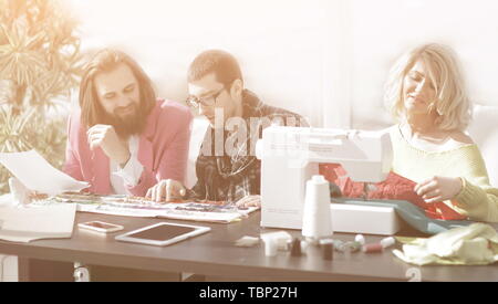 Lächelnd Geschäftsfrau maßgeschneiderte sitzen an der Nähmaschine Stockfoto