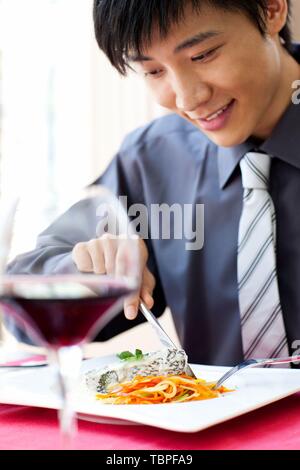 Creative Foto: Ein junger Mann genießt ein Abendessen in einem Restaurant in Shanghai, China. Stockfoto