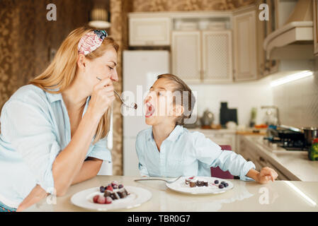 Mutter mit Kind Verkostung Dessert und Spaß Stockfoto