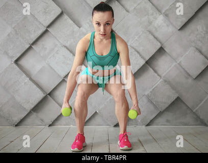 Sportliche Frau Training mit Hanteln in der Turnhalle Stockfoto