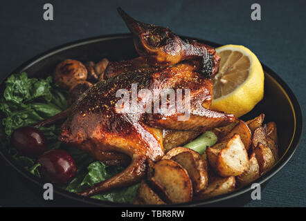 Geheime gebratene Taube mit Kartoffeln und Pilzen, Zitrone. Stockfoto