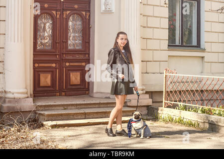 Junges Mädchen mit niedlichen Mops Hund im Freien Stockfoto