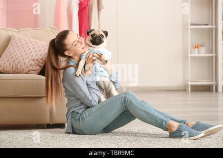 Junges Mädchen mit niedlichen Mops Hund zu Hause Stockfoto