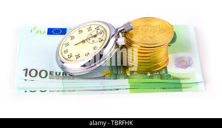 Bitcoins auf einem Stapel von Hundert Euro und einer Glühlampe Uhr auf weißem Hintergrund Stockfoto