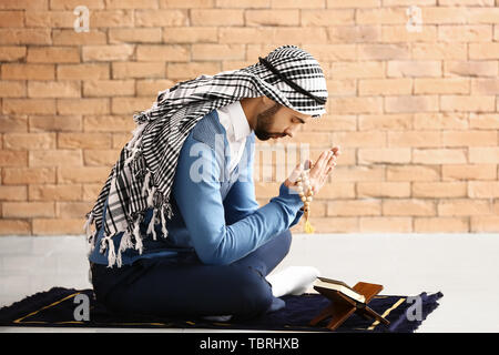 Jungen muslimischen Mann, der betet in Innenräumen Stockfoto