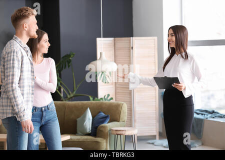 Real estate agent zeigt ein junges Paar ein neues Haus Stockfoto