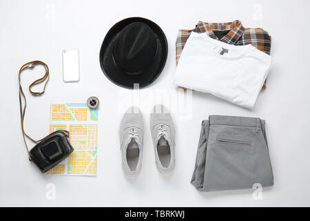 Stilvolle männliche Kleidung mit Foto Kamera, Handy, Karte und Kompass auf weißem Hintergrund. Travel Concept Stockfoto