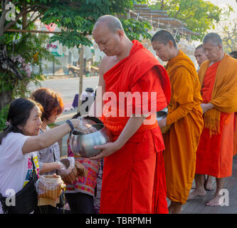 Lampeng, Tahiland - 2019-03-07-Linie der Mönche erhalten Geschenke von Nahrungsmitteln aus Anbeter entlang der Straße. Stockfoto