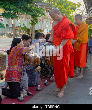 Lampeng, Tahiland - 2019-03-07-Linie der Mönche erhalten Geschenke von Nahrungsmitteln aus Anbeter entlang der Straße. Stockfoto