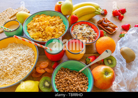 Abwechslungsreiches und gesundes Frühstück Obst, Getreide, Milch, getrocknete Pflaumen, Erdbeeren und Apple Stockfoto