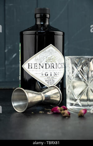 70 cl Flasche Hendricks destillierter Gin mit Glas und Eis auf dunklen rustikalen Hintergrund. Lag neben den Shaker und malenikie rosa Rosen. Stockfoto