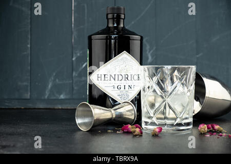 70 cl Flasche Hendricks destillierter Gin mit Glas und Eis auf dunklen rustikalen Hintergrund. Lag neben den Shaker und malenikie rosa Rosen. Stockfoto