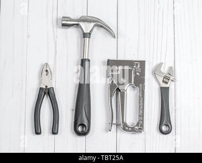 Tools. Schlüssel, Hammer und Zange auf einem weißen Holz- Hintergrund Stockfoto