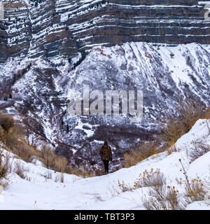 Quadrat Mann stand in der Mitte der Berge mit Schnee und Gräser Stockfoto