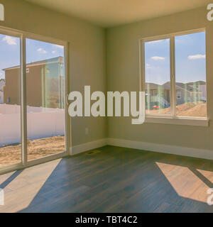 Platz Epmty Zimmer von einem neuen Haus mit beige Wandfarbe und glänzend braune Holz Boden Stockfoto