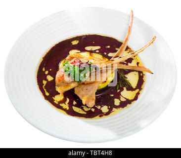 Gebratenes hammelfleisch Rippen mit gebackenen Auberginen und Wein Sauce serviert. Auf weissem Hintergrund Stockfoto