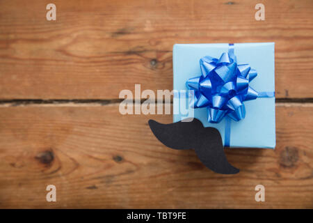 Vatertag blau verpackte Geschenk mit Papier Schnurrbart. Der glückliche Vater Tag Hintergrund Stockfoto