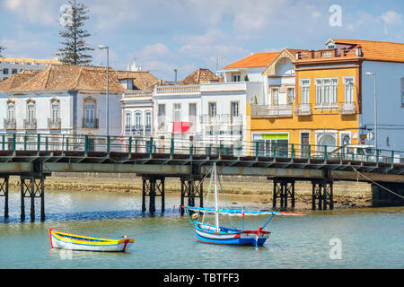 Fußgänger-Brücke über den Fluss Gilao und Boote aus Holz. Altstadt von Tavira, Algarve, Portugal Stockfoto