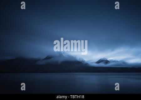 Am frühen Morgen Wolken bilden über die schneebedeckten Berge hinter den Genfer See mit Lausanne im Vordergrund. Stockfoto