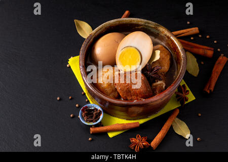 Essen Konzept thailändische Küche Schweinebauch und Ei mit fünf Spice duftenden Eintopf Moo Palo auf schwarzem Schiefer mit Kopie Raum Stockfoto