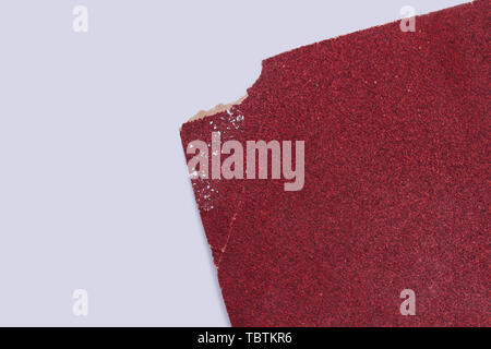 Red Sandpapier auf weißem Hintergrund. Stück Schleifpapier und Kopieren. Stockfoto