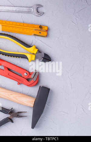 Verschiedene Construction Tools, Ansicht von oben. Unterschiedliche Werkzeuge zur Reparatur auf grauem Hintergrund mit kopieren. Stockfoto