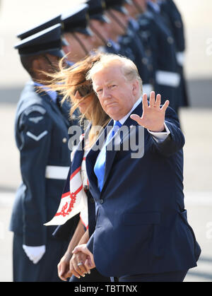 US-Präsident Donald Trump Wellen in den Medien, wie er und seine Frau, Melania, am Flughafen Stansted, Essex, nach der Ankunft auf der Air Force One, für den Beginn seiner dreitägigen Staatsbesuch in Großbritannien. Stockfoto