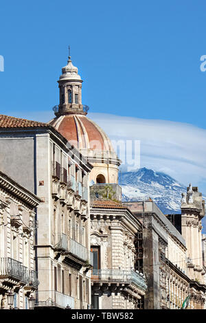 Schöne Nahaufnahme, Fotografie von Catania Kathedrale der Heiligen Agatha mit angrenzenden historischen Gebäuden und den Ätna im Hintergrund. Schnee auf der Spitze der bekannten Vulkan. Stockfoto