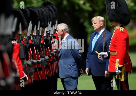 US-Präsident Donald Trump und die der Prinz von Wales (links) prüft die Ehrengarde in einem feierlichen Willkommen im Buckingham Palace, London, am ersten Tag seiner dreitägigen Staatsbesuch in Großbritannien. Stockfoto