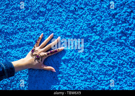 Arm mit einem traditionellen Henna Tattoo auf dem Hintergrund der blauen Wand. Rabat, Marokko. Afrika Stockfoto