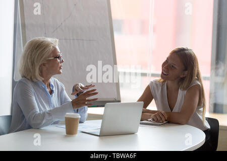 Reife Geschäftsfrau Mentor im Gespräch mit weiblichen intern im Konferenzraum. Stockfoto