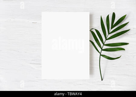 Feminine Hochzeit Schreibwaren Mock-up, Schreibtisch Szene. Leere Grußkarte und Green Palm Leaf auf weißem Hintergrund schäbig Tabelle. Tropischer Sommer gestaltete phot Stockfoto