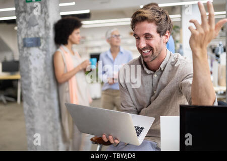 Glückliche junge Kollegen Mann bei der Arbeit im Büro Stockfoto