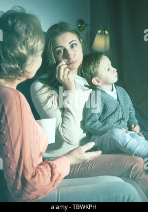 Erwachsene Frau schreit gerade nach Film und ihre Mutter ist ihr tröstend in den Abend zu Hause. Stockfoto