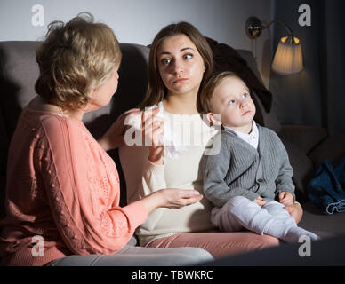 Erwachsene Frau schreit gerade nach Film und ihre Mutter ist ihr tröstend in den Abend zu Hause. Stockfoto